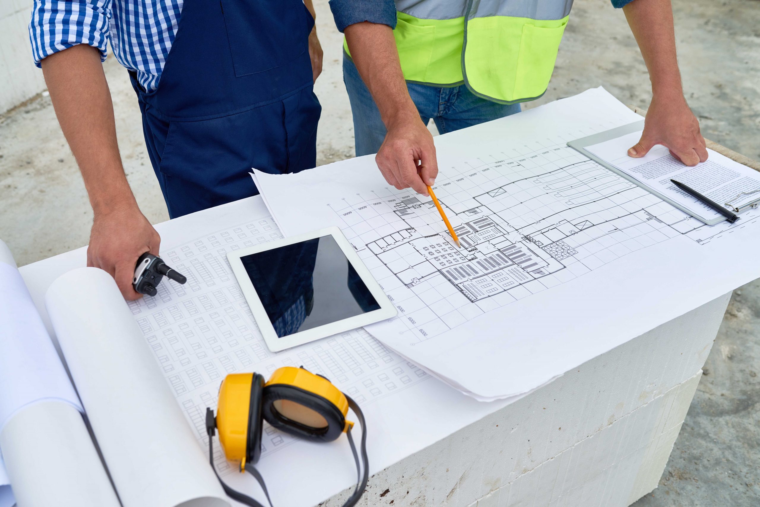 A project manager and construction worker looking over building plans.