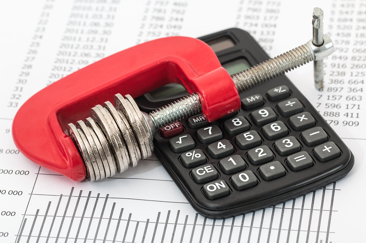 a calculator with coins on top to show the importance of budgeting during a commercial construction project